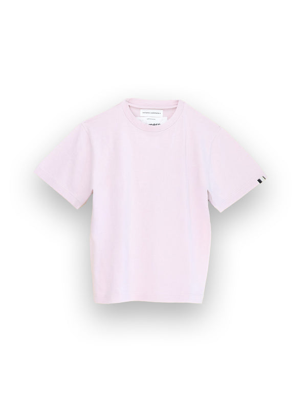 Das Hemd Extreme Cashmere N°268 Cuba aus einem Baumwoll-Kaschmir-Gemisch ist ein hellrosa Kurzarm-T-Shirt mit Rundhalsausschnitt. Auf der Innenseite des Kragens ist ein kleines weißes Etikett zu sehen, das auf weißem Hintergrund abgebildet ist.